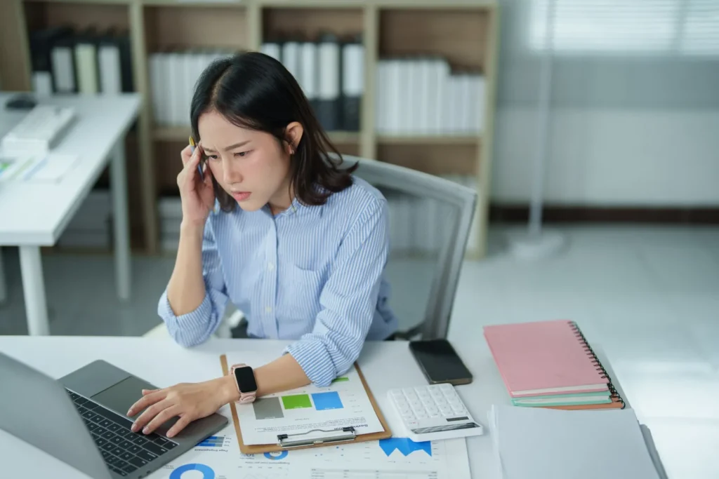 New employee looking stressed while completing onboarding tasks at their desk