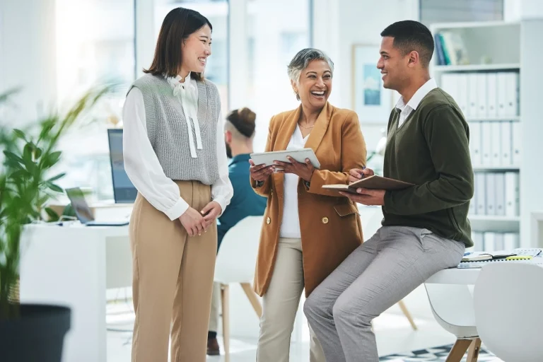 Three colleagues discussing work in a modern office.