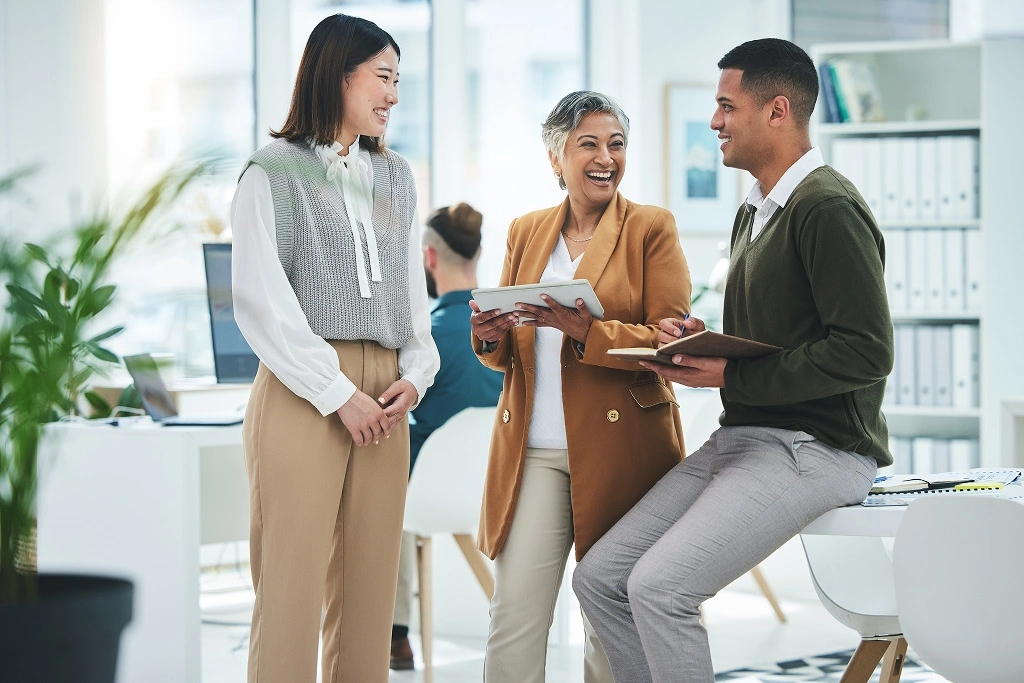 Three colleagues discussing work in a modern office.