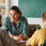 quality teacher at independent school helping her students learn in a classroom