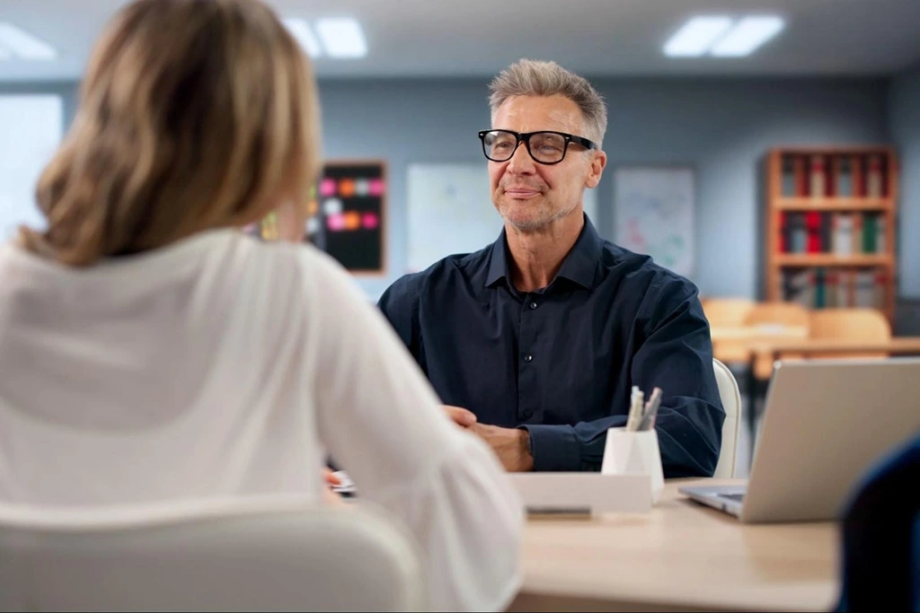 School principal interviewing a teaching candidate in a classroom during the hiring season